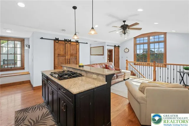 a living room with stainless steel appliances kitchen island furniture and a chandelier