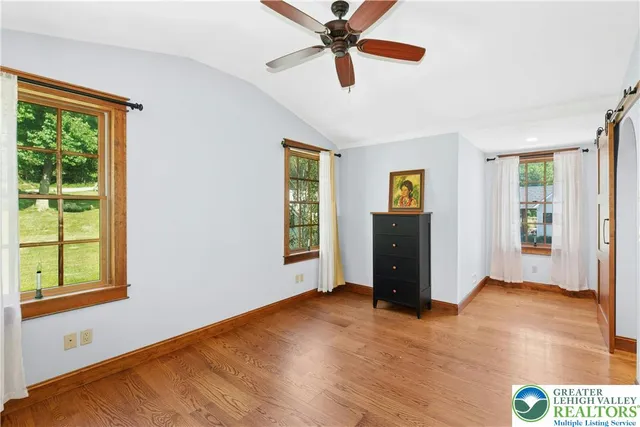 a view of empty room with wooden floor