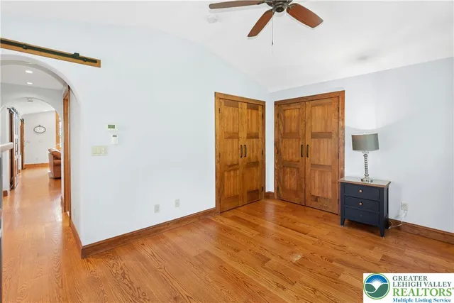 a view of a hallway with wooden floor and closet