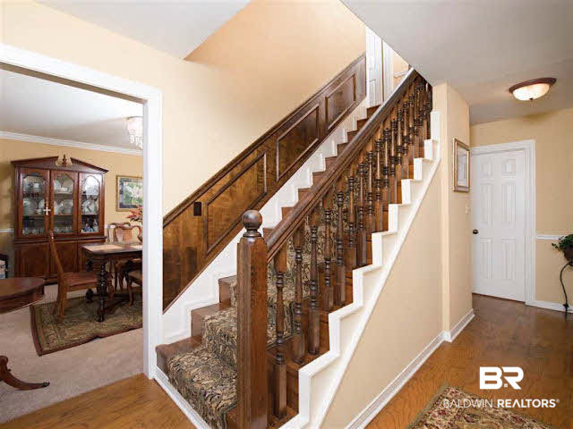 640 Spanish Main Spanish Fort, AL 36527 - Photo 4 of 33 Beautiful foyer with rich wood paneling along staircase that takes you to the upstairs master with on suite, two additional bedrooms and another full bath. There is also a master bedroom downstairs