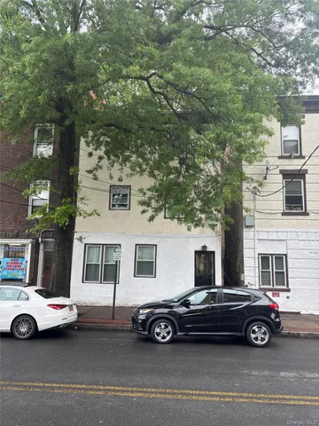 a car parked in front of a white house