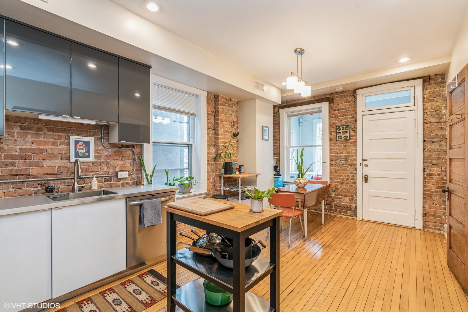 Undisclosed Address Chicago, IL 60622 - Photo 5 of 11 a kitchen with stainless steel appliances a stove a sink dishwasher and a dining table with wooden floor