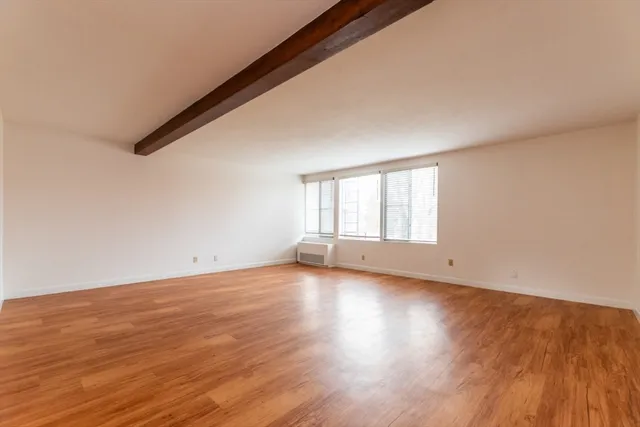 a view of a room with wooden floor and window