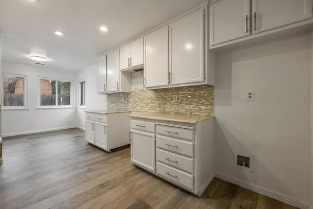 a kitchen with granite countertop white cabinets and white appliances