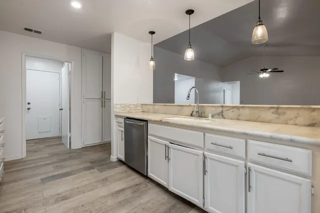 a spacious kitchen with a sink and cabinets