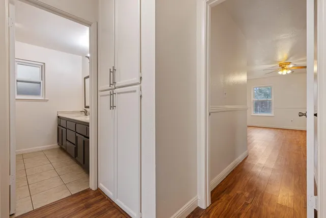 an empty room with wooden floor and windows