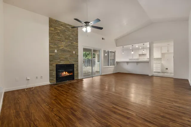 a view of empty room with wooden floor and fireplace
