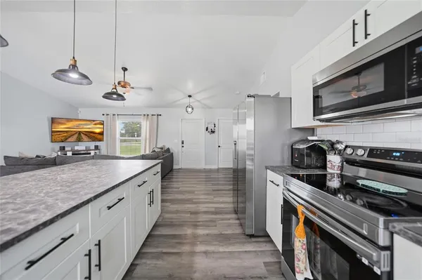 a kitchen with stainless steel appliances granite countertop a stove a sink and a microwave