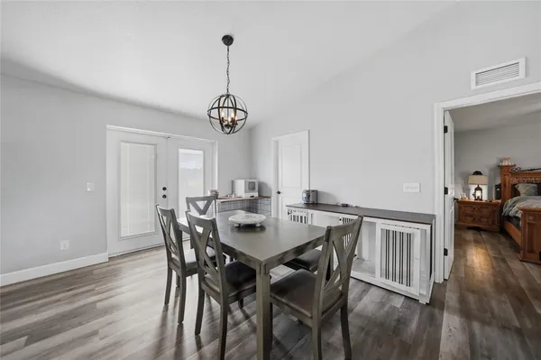 a view of a dining room and livingroom with furniture wooden floor a chandelier