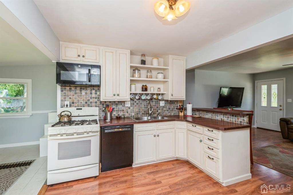 24 Markham Road Edison, NJ 08817 - Photo 6 of 20 a kitchen with a stove a sink and a microwave