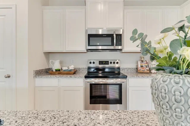 a kitchen with stainless steel appliances granite countertop a stove a microwave a sink and cabinets