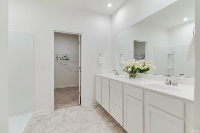 a spacious bathroom with a shower sink and mirror