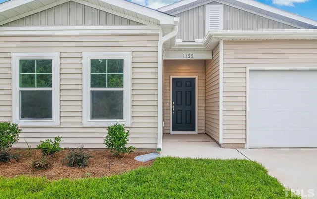 a front view of a house with a yard and outdoor seating
