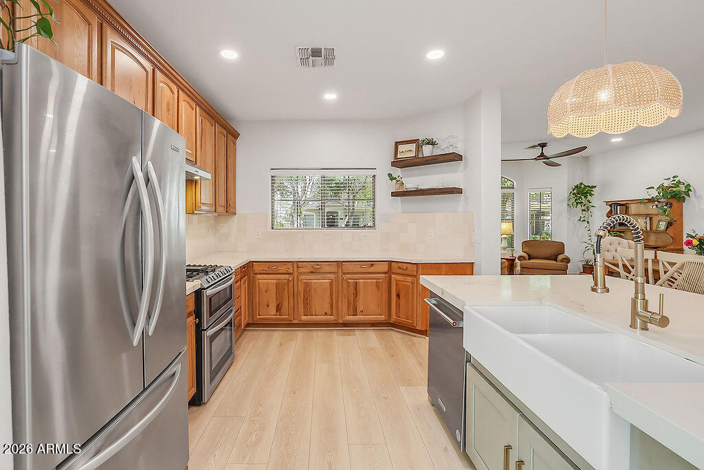 3116 East Tamarisk Street Gilbert, AZ 85296 - Photo 16 of 35 a kitchen with stainless steel appliances granite countertop a refrigerator and a sink