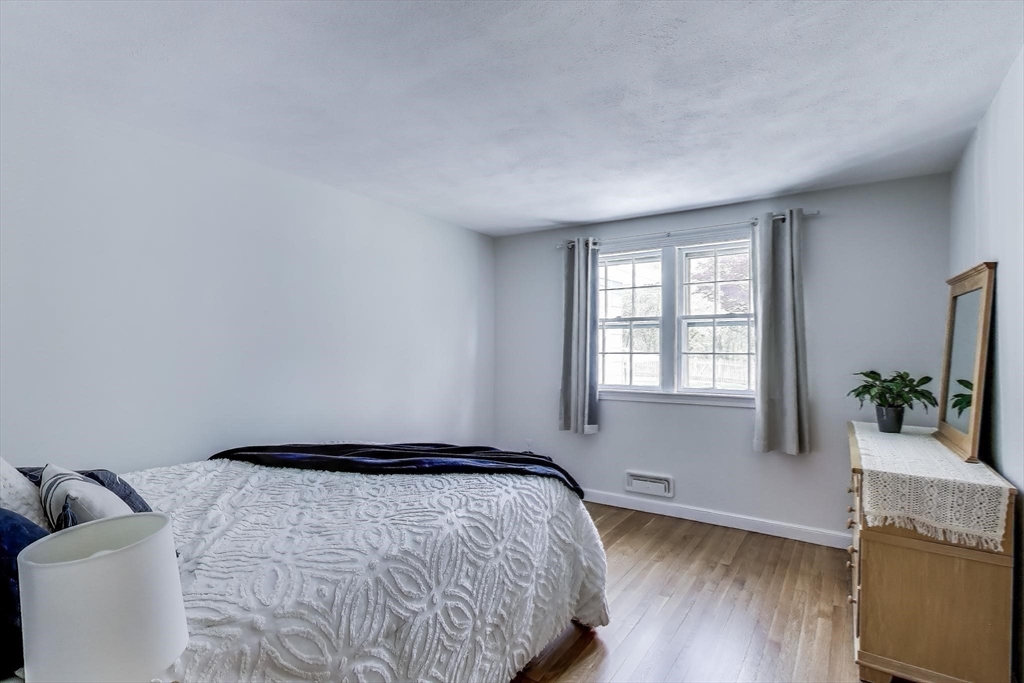 24 Spruce Drive Westwood, MA 02090 - Photo 16 of 32 a bedroom with a bed and a potted plant next to a window