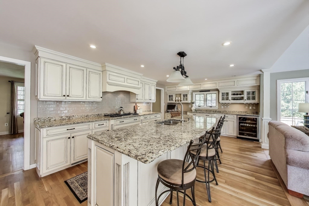 24 Spruce Drive Westwood, MA 02090 - Photo 4 of 32 a kitchen with stainless steel appliances granite countertop a stove top oven a sink a dining table and chairs