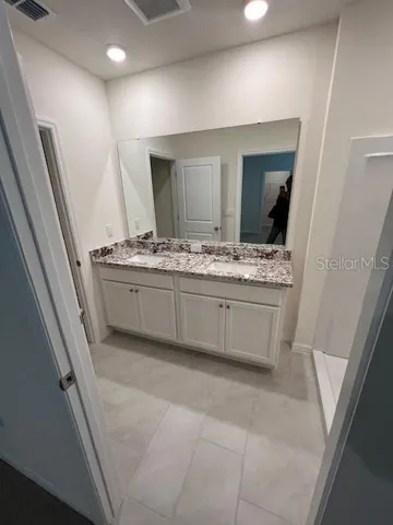 a bathroom with a double vanity sink and mirror