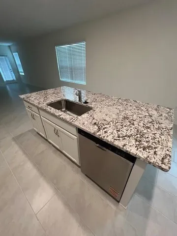 a view of kitchen island with sink washer and natural light