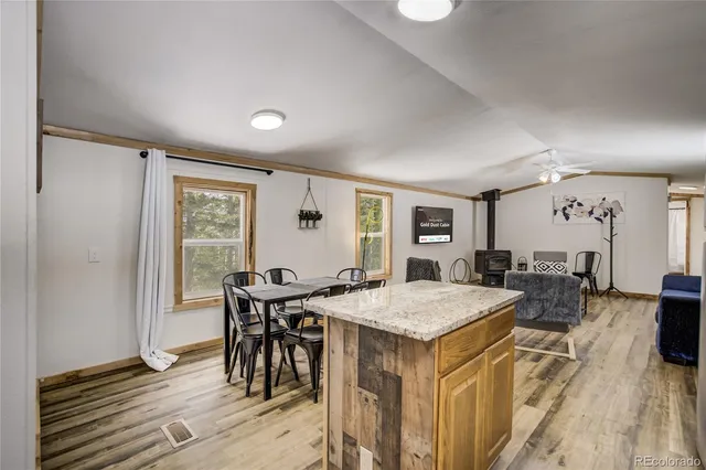 a open kitchen with a table chairs refrigerator and microwave
