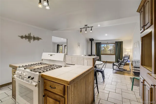 a kitchen with a stove a table and chairs in it