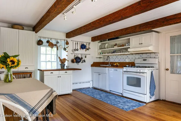 a kitchen with stainless steel appliances a stove a sink cabinets and wooden floor