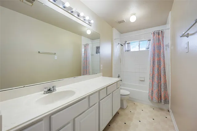 a bathroom with a sink a toilet a mirror and shower