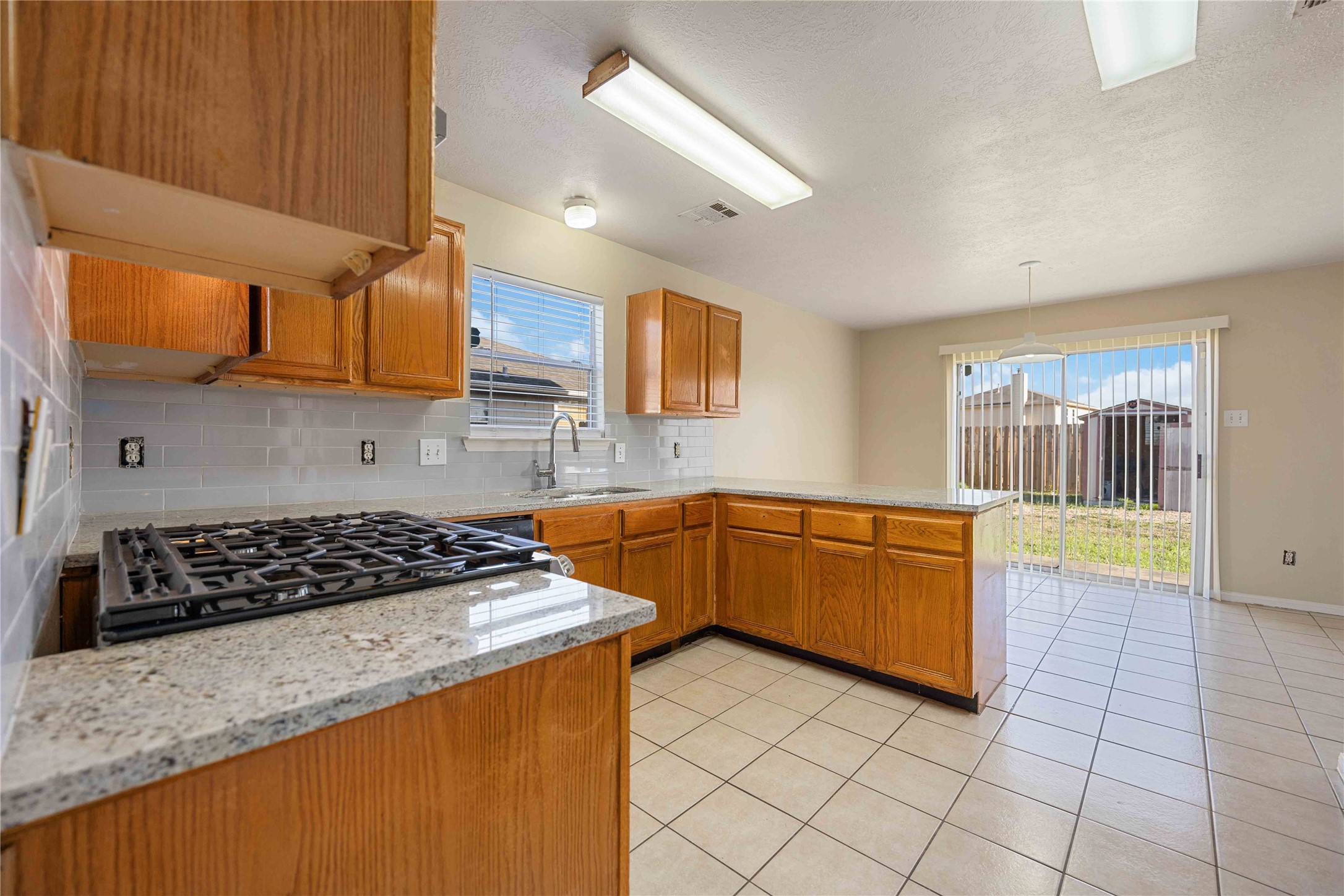 4806 Cotton Ridge Trail Houston, TX 77053 - Photo 9 of 25 a kitchen with granite countertop a stove a sink a refrigerator and cabinets