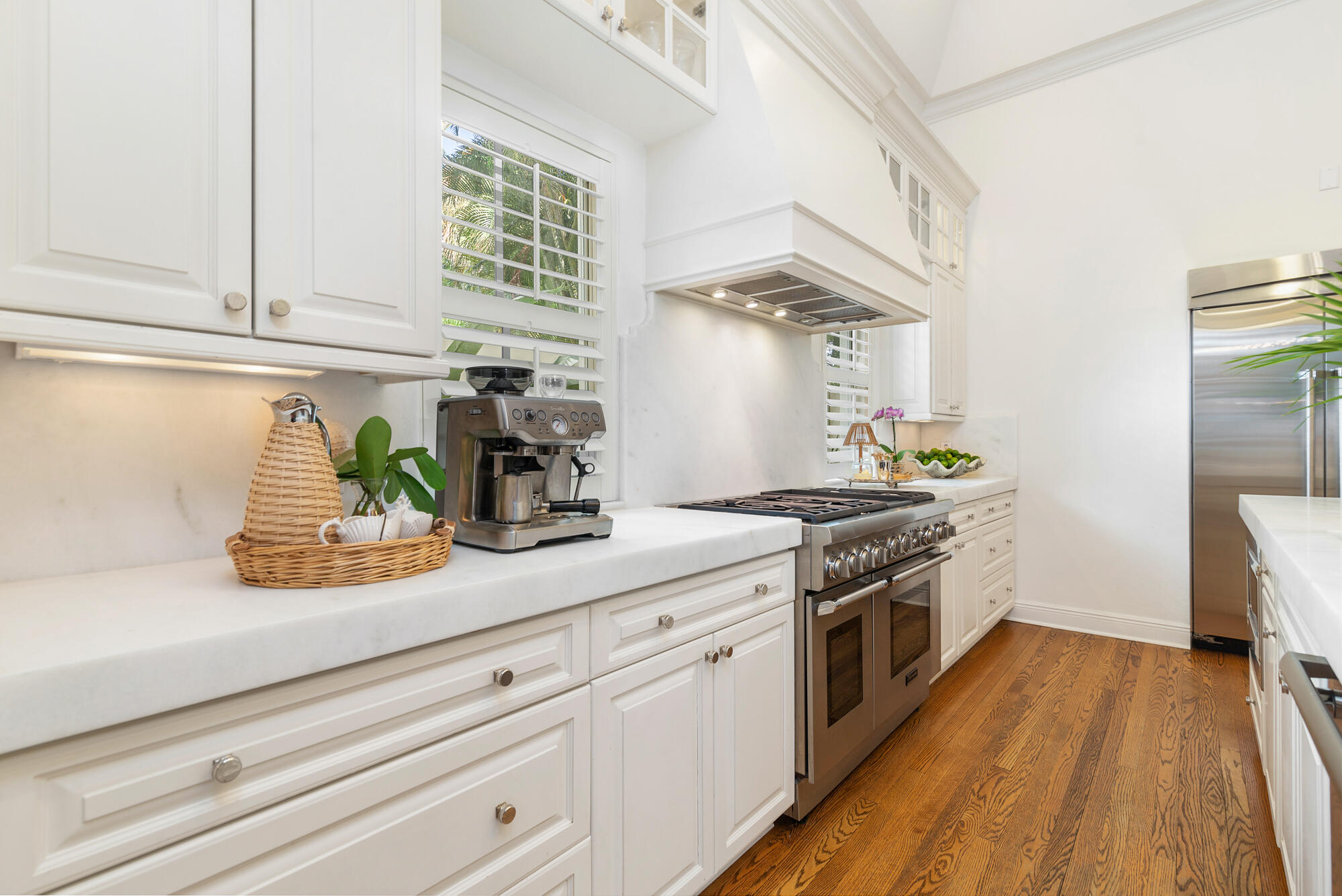 119 Alpine Road West Palm Beach, FL 33405 - Photo 7 of 30 a kitchen with stainless steel appliances white cabinets wooden floor and a window