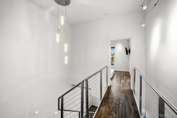 a view of a hallway with wooden floor and staircase