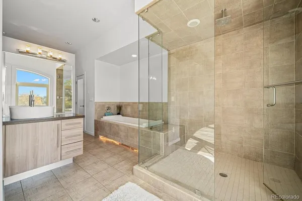 a bathroom with a tub sink and mirror