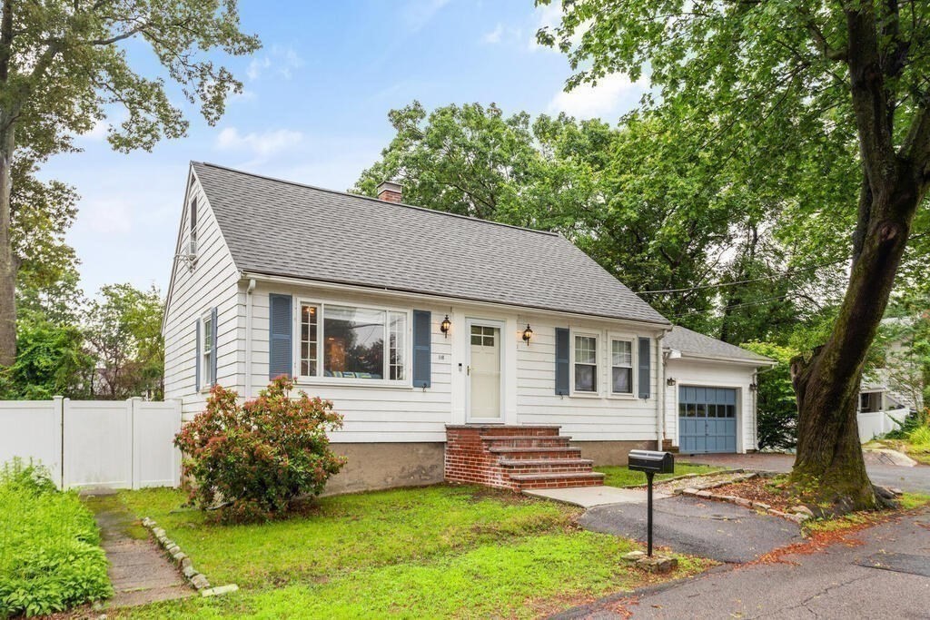 a front view of a house with a yard and trees