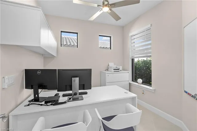 a living room with a computer on a desk and a window