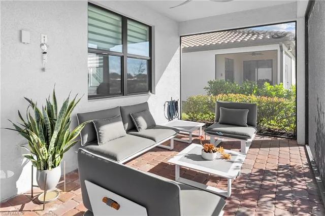 a living room with patio furniture and a floor to ceiling window