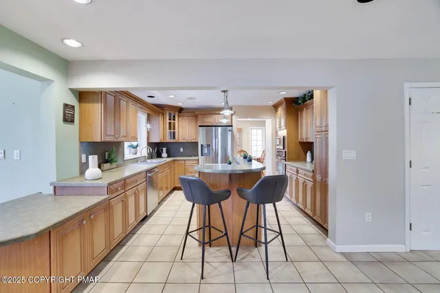 a kitchen with stainless steel appliances kitchen island granite countertop a sink and cabinets