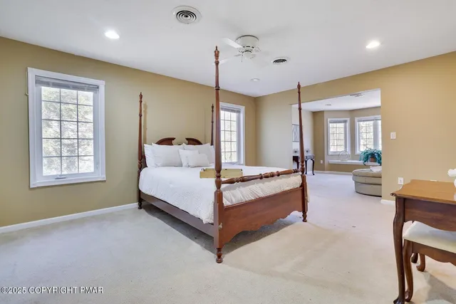 a spacious bedroom with a bed a table and chair