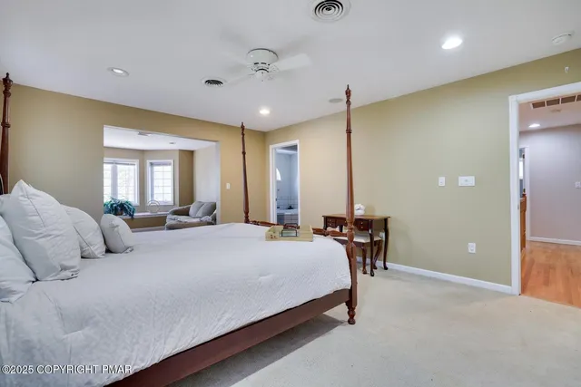 a bedroom with a bed lamps and chairs