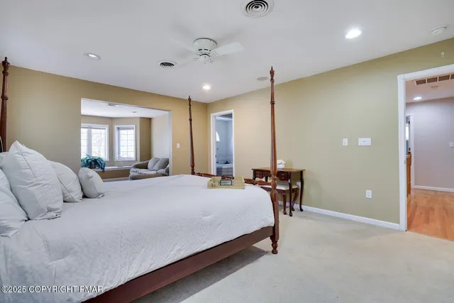 a bedroom with a bed lamps and chairs