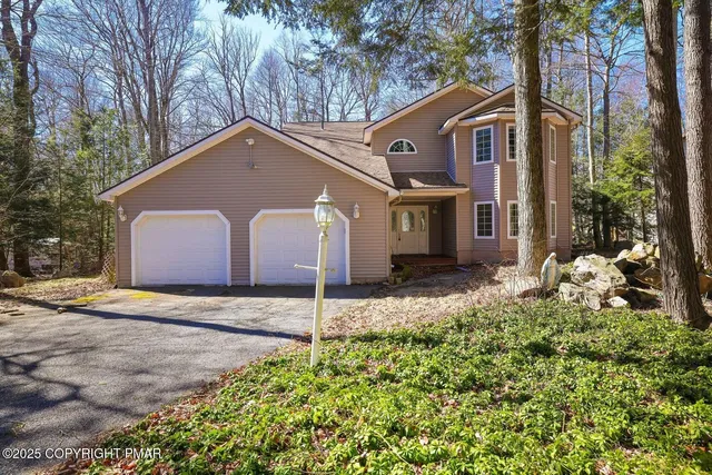 a front view of a house with a yard and garage