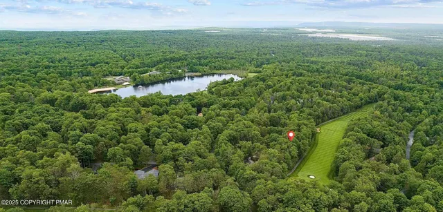 an aerial view of residential houses with outdoor space and trees