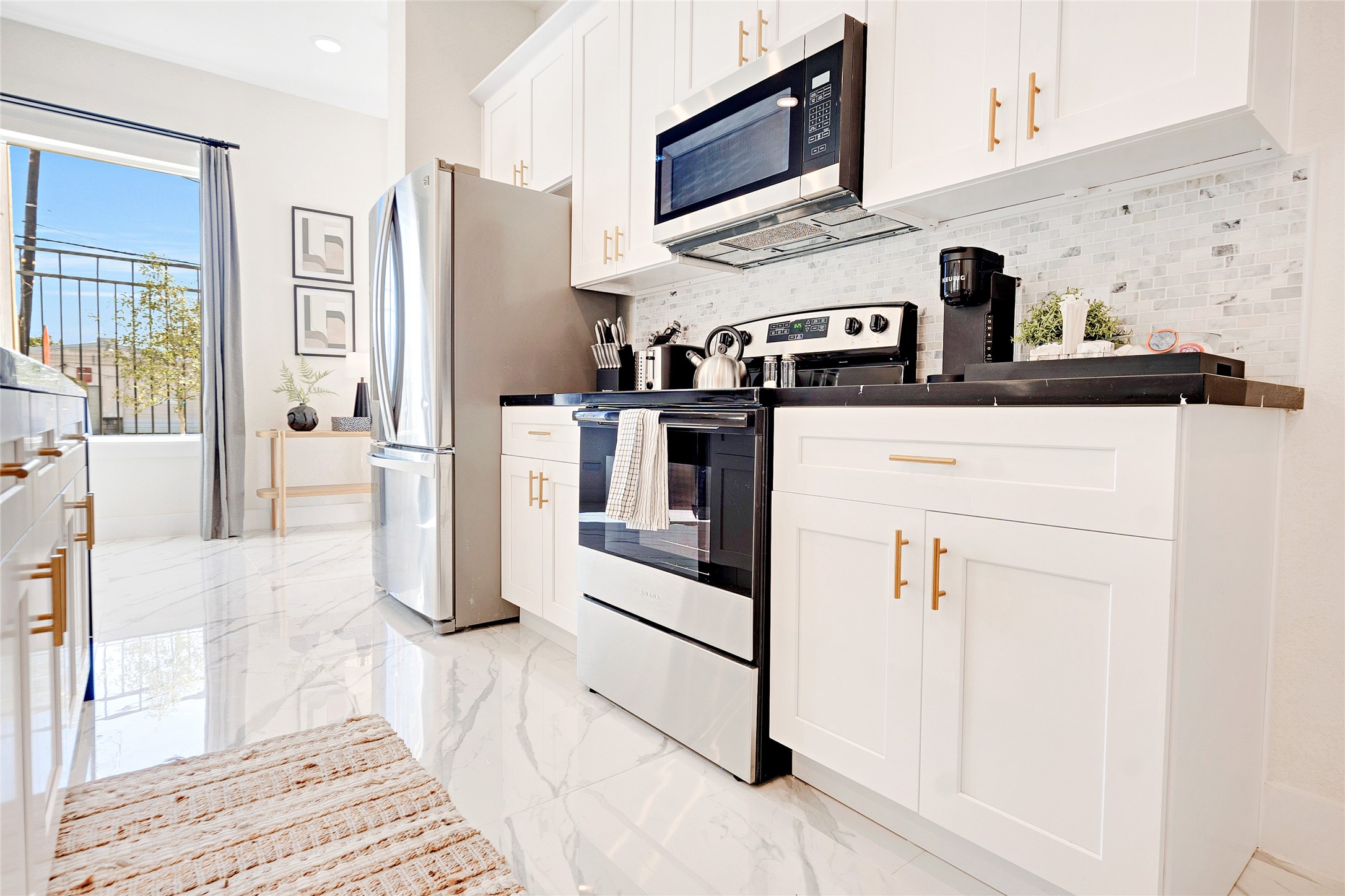 a kitchen with stainless steel appliances granite countertop a refrigerator a stove and a sink with wooden floor