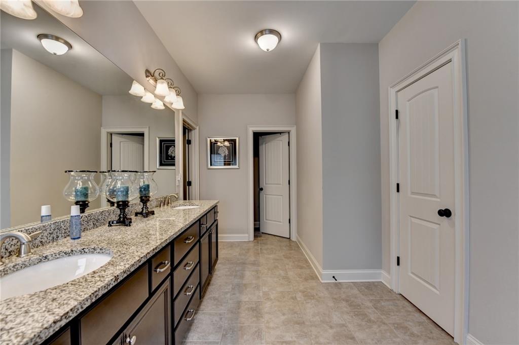 5930 Caveat Court Suwanee, GA 30024 - Photo 58 of 98 a spacious bathroom with a granite countertop double vanity sink a mirror and a shower