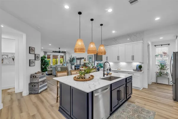 a kitchen with stainless steel appliances granite countertop a stove a sink dishwasher a dining table and chairs with wooden floor