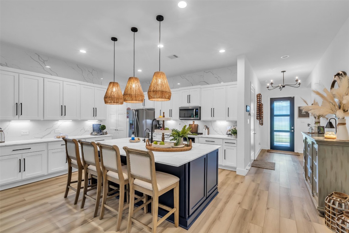 307 Springfield Terrace Drive Conroe, TX 77304 - Photo 5 of 30 a kitchen with stainless steel appliances granite countertop a stove a sink dishwasher a dining table and chairs with wooden floor