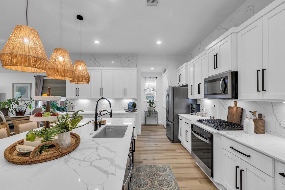 307 Springfield Terrace Drive Conroe, TX 77304 - Photo 6 of 30 a kitchen with sink a stove and cabinets