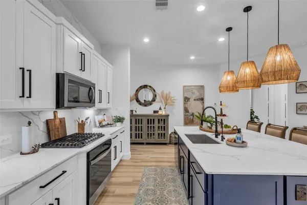 a kitchen with stainless steel appliances granite countertop a sink a stove and a wooden floors