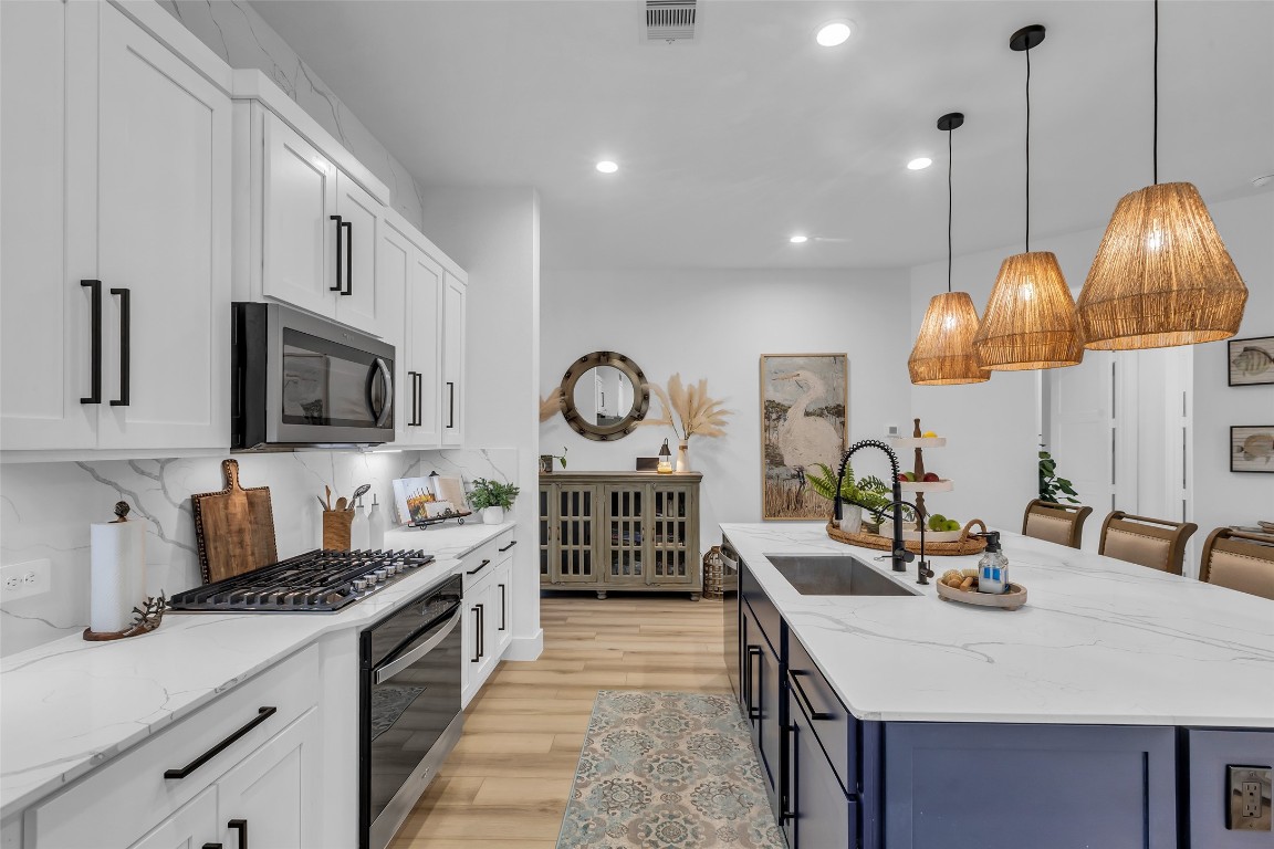 307 Springfield Terrace Drive Conroe, TX 77304 - Photo 7 of 30 a kitchen with stainless steel appliances granite countertop a stove a sink dishwasher a dining table and chairs with wooden floor