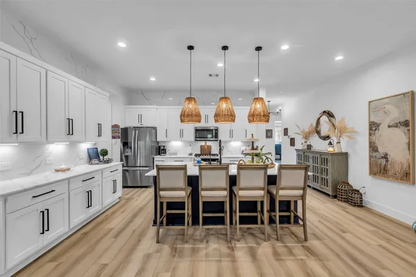 a large kitchen with lots of counter space a sink appliances and dining table