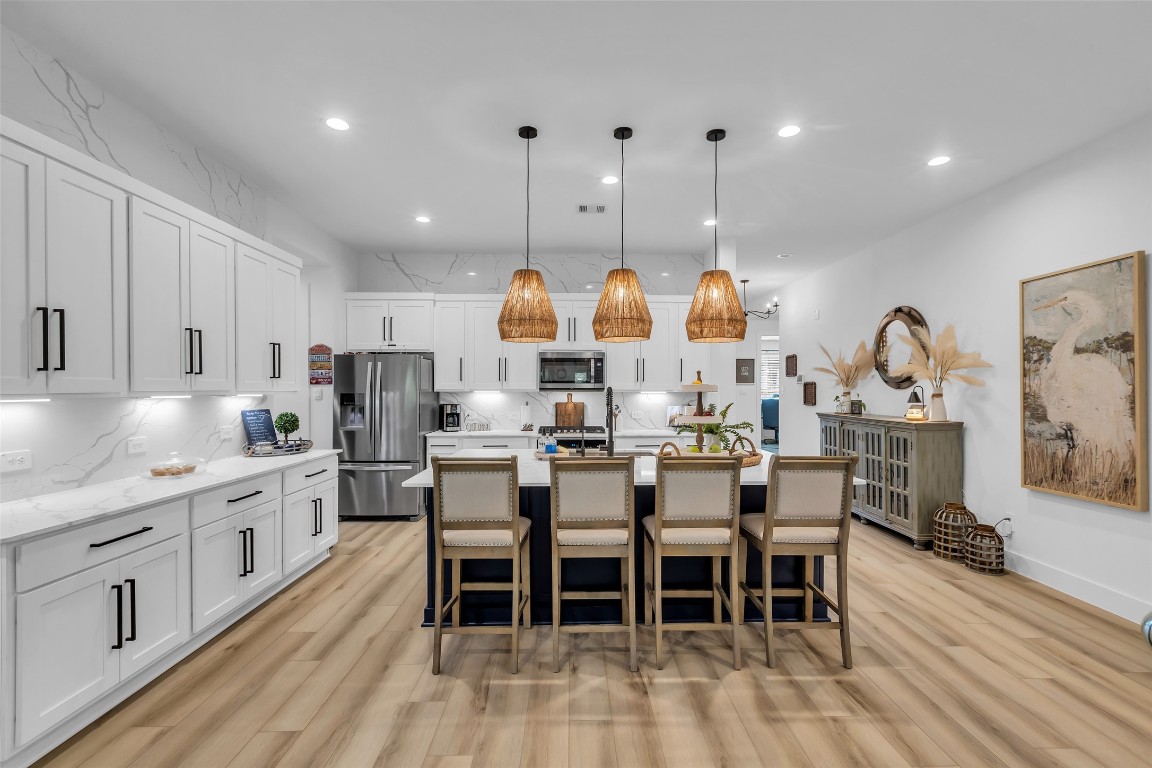 307 Springfield Terrace Drive Conroe, TX 77304 - Photo 9 of 30 a kitchen with stainless steel appliances kitchen island granite countertop a table chairs sink and cabinets