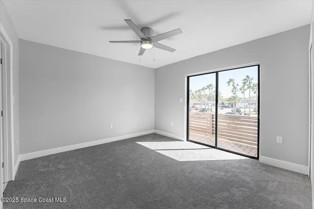 an empty room with fan and windows