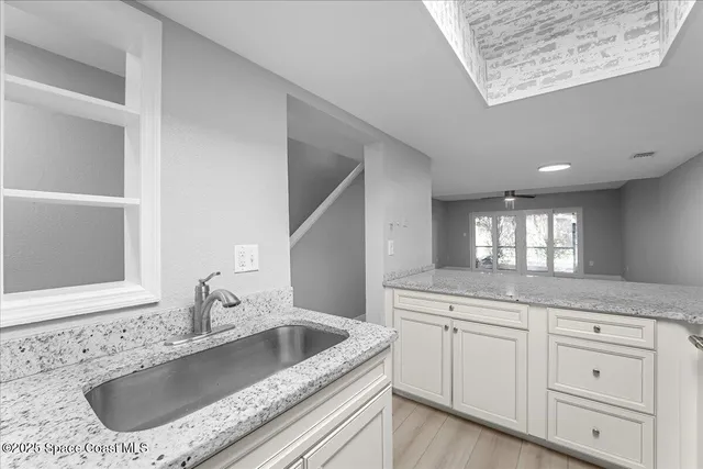a kitchen with granite countertop a sink and a window